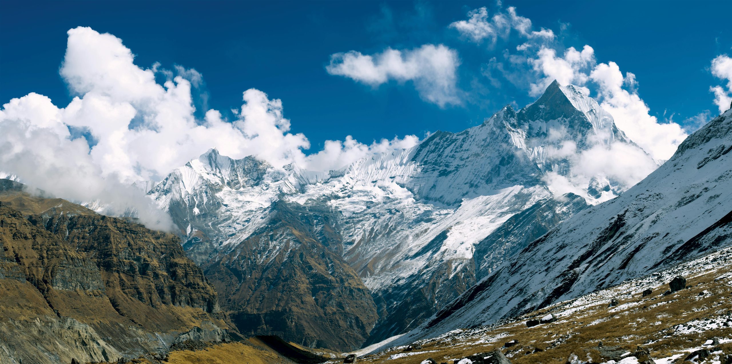 Majestic snow-capped peaks of Annapurna in clear daylight, perfect for outdoor enthusiasts.